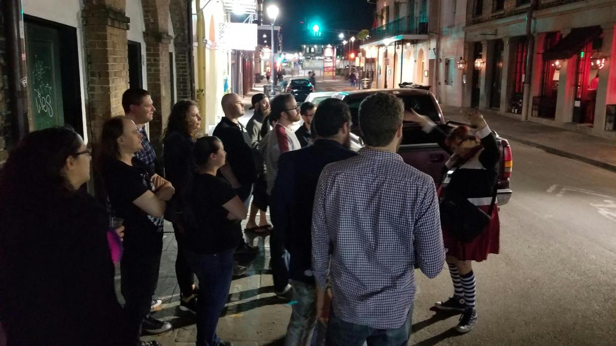 um grupo de pessoas paradas em uma rua à noite