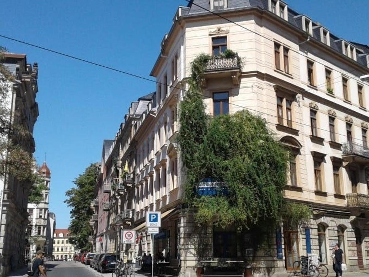 Un gran edificio en una calle de la ciudad con un árbol.