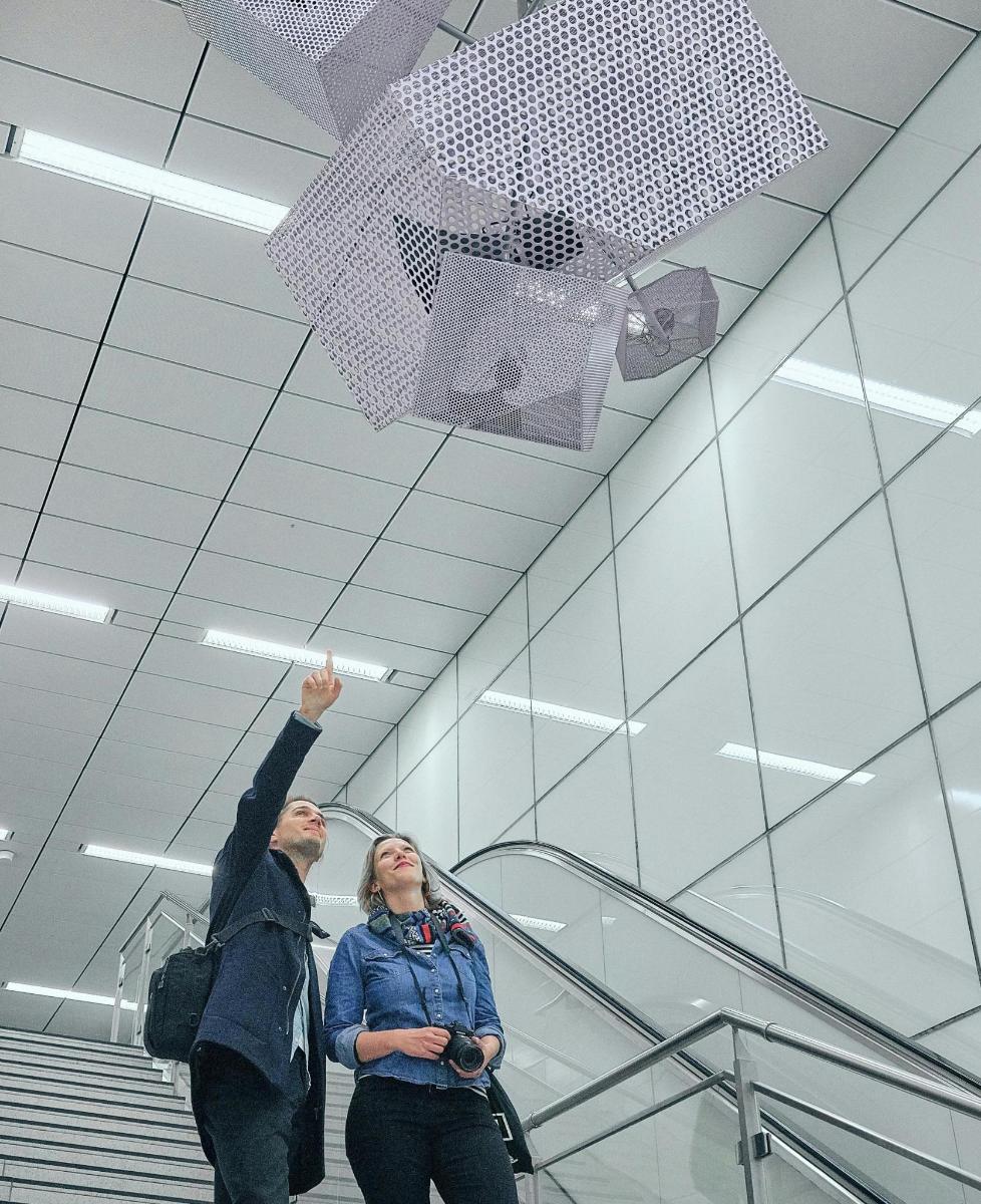 un homme et une femme debout sur un escalator