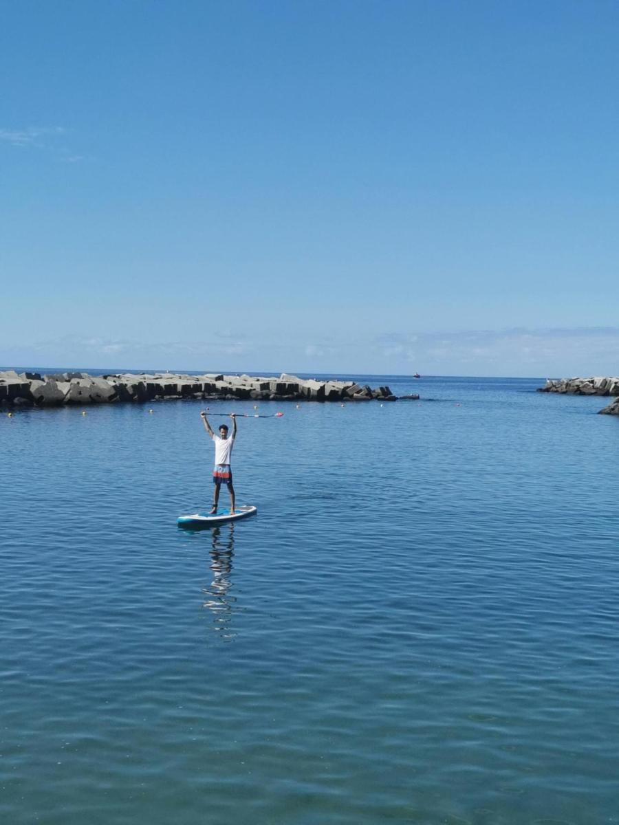 una persona parada sobre una tabla de remo en el agua