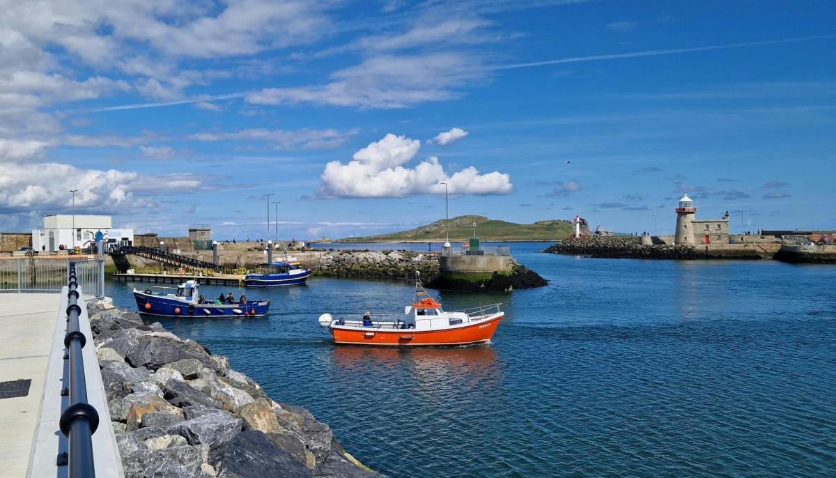 three boats in a body of water with a lighthouse