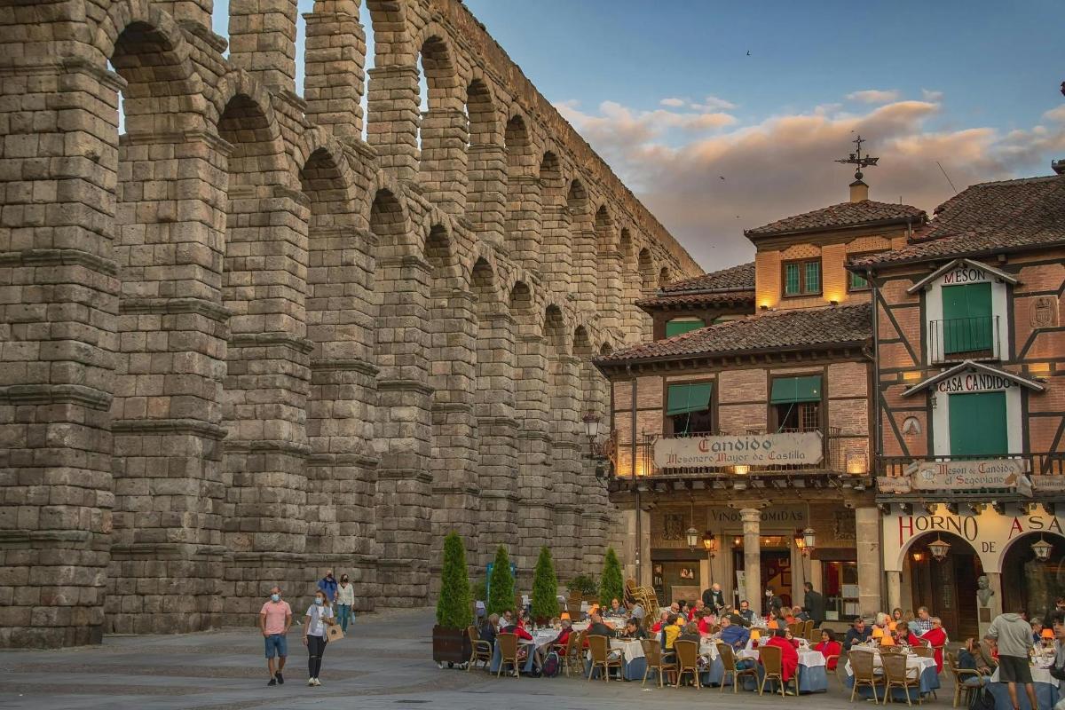 un grup de persones assegudes a taules davant d'un edifici