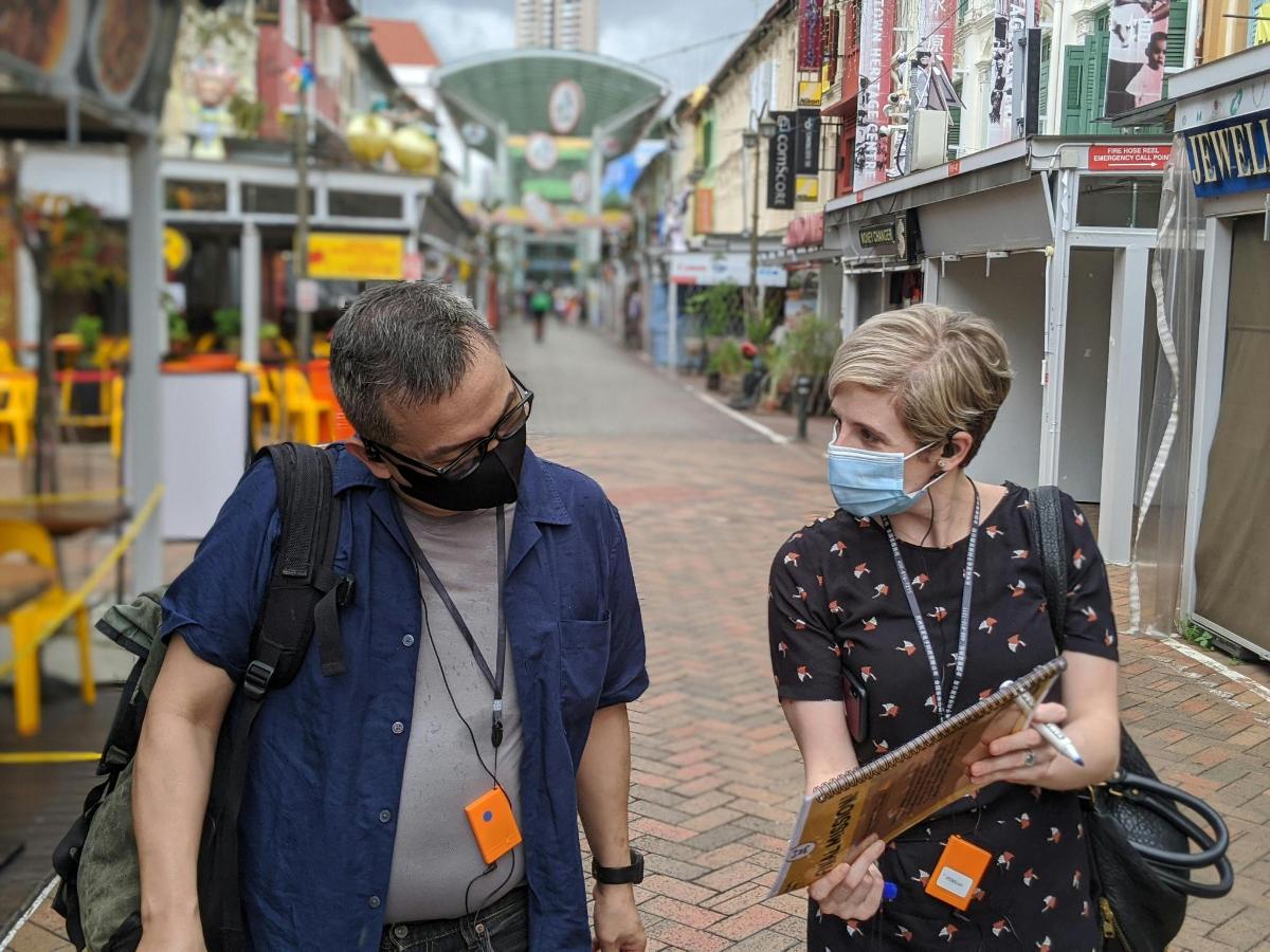 a man and a woman wearing masks walking down a street