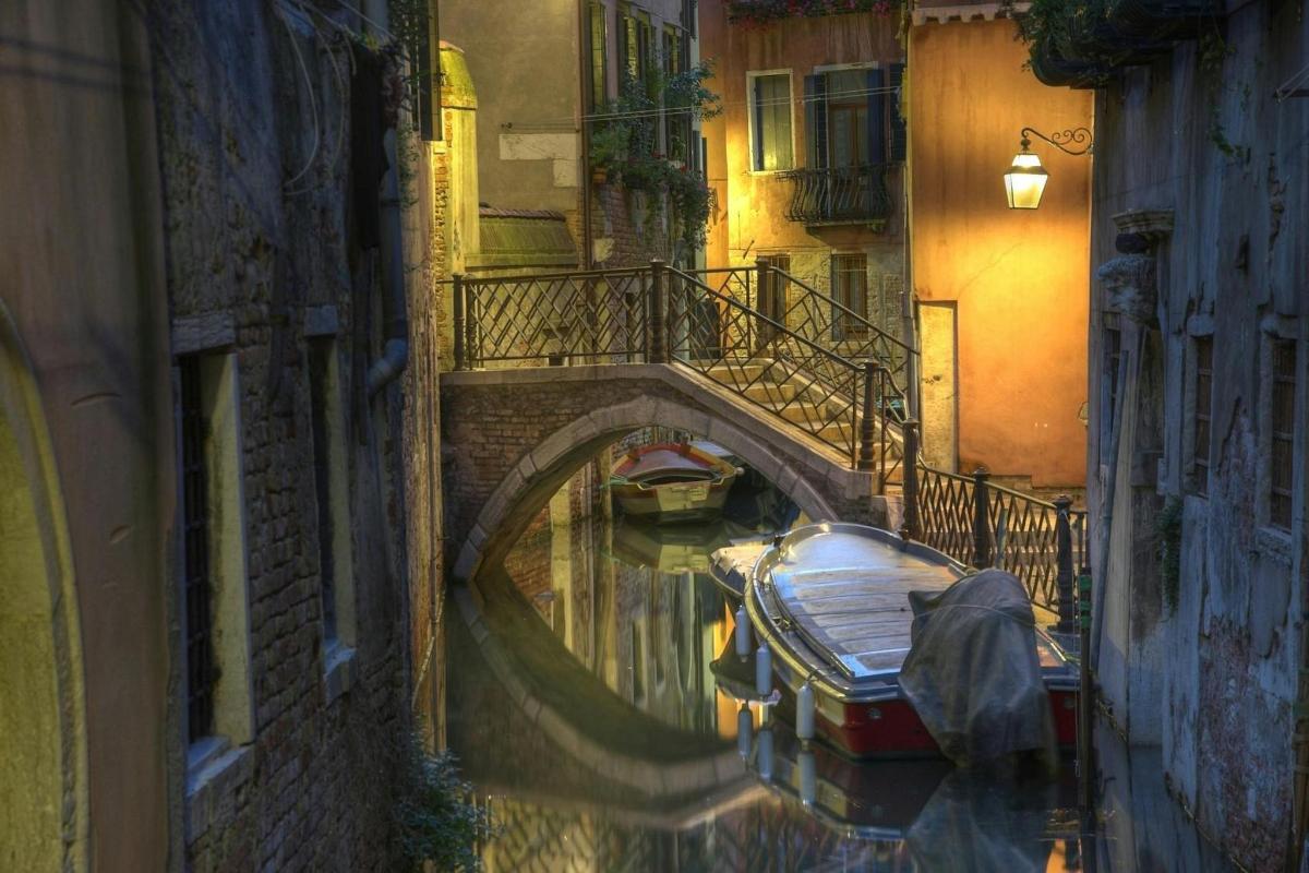 Un canal con un puente y un barco en el agua.