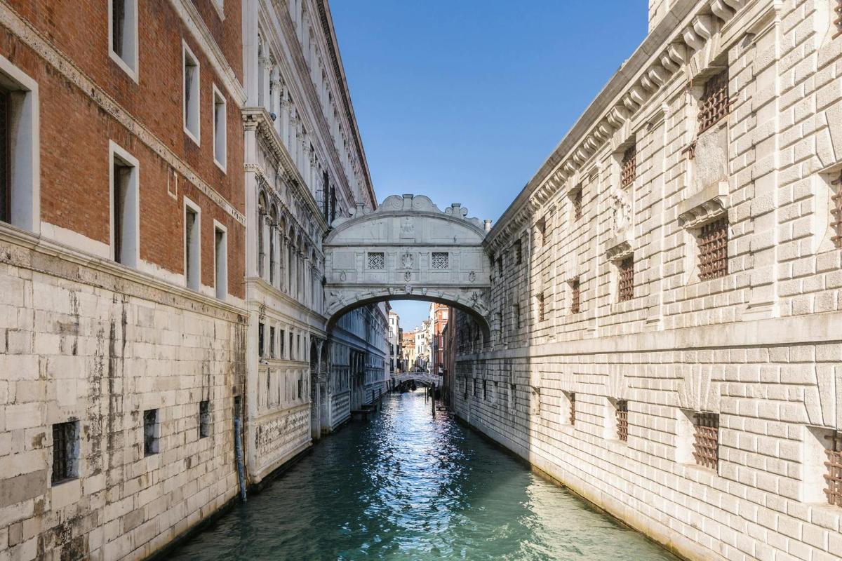 a bridge over a canal between two buildings