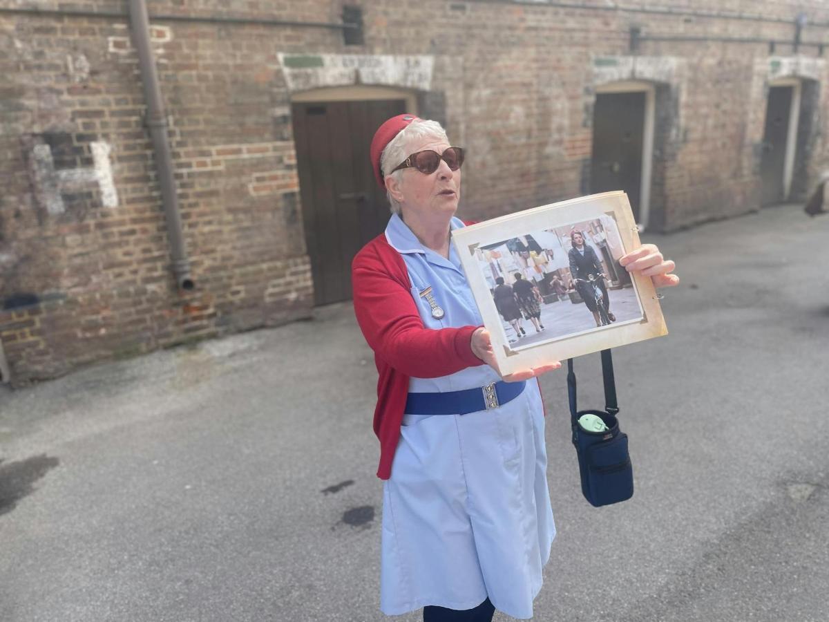 an older woman holding up a picture of herself