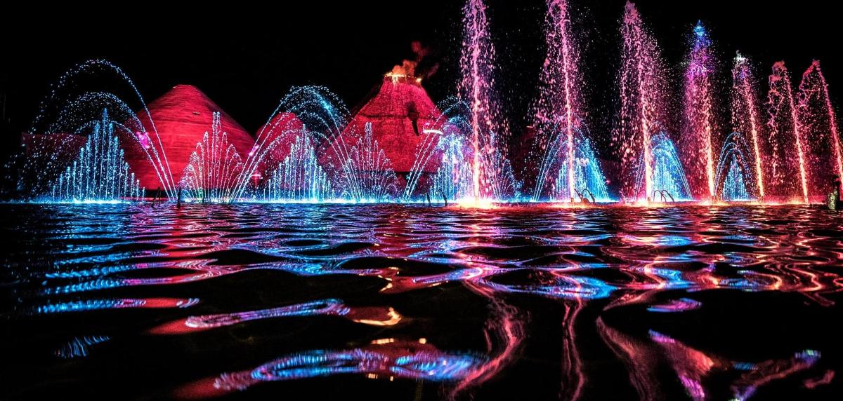 una fontana nell'acqua di fronte a una città