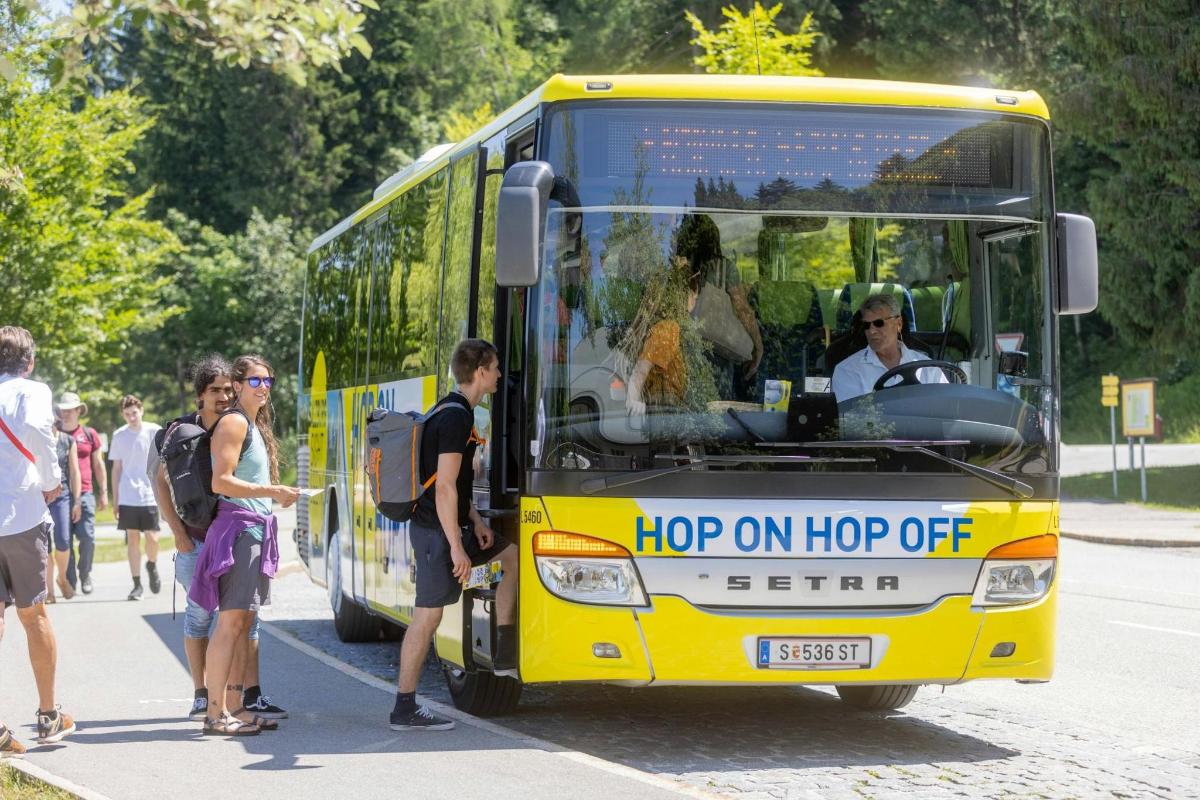 egy csoport ember áll egy sárga busz előtt