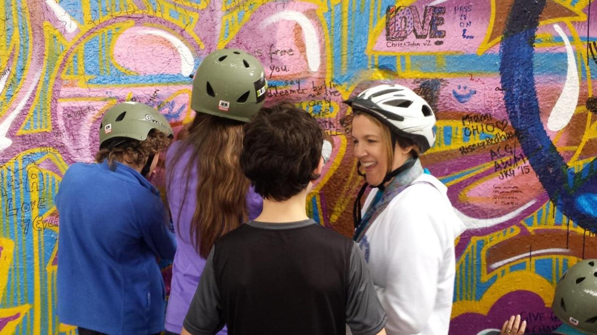 eine Gruppe von Menschen steht vor einer Wand mit Graffiti