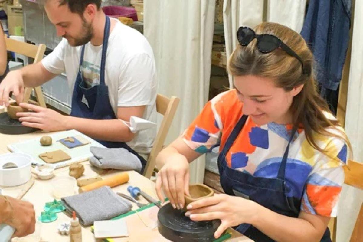 Una mujer está haciendo una olla en un torno de alfarero.