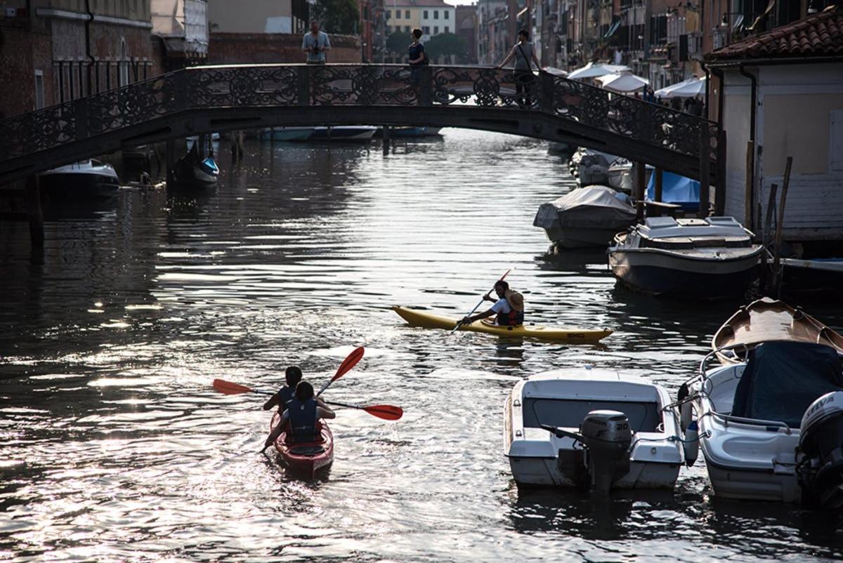 due persone in kayak su un fiume con barche