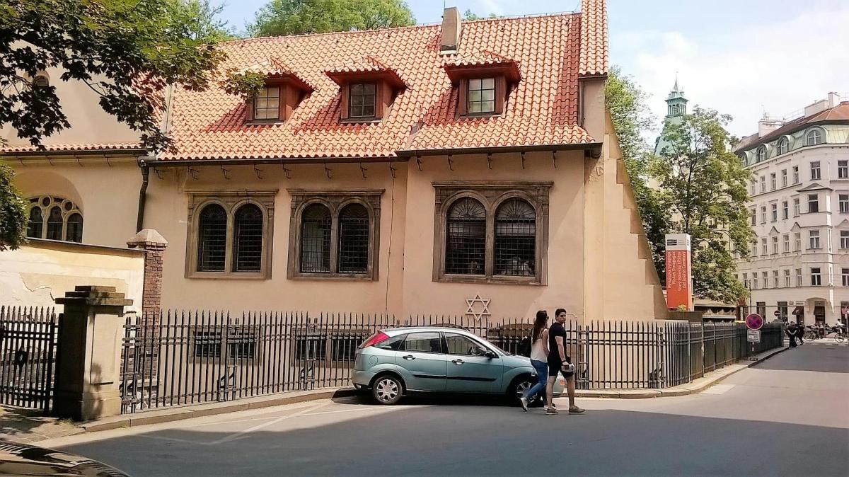 ženska, ki stoji poleg majhnega avtomobila pred stavbo