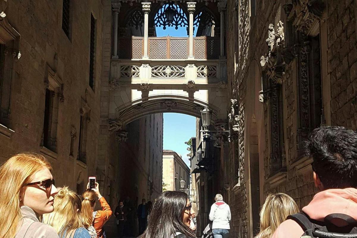 um grupo de pessoas caminhando por uma rua sob um arco