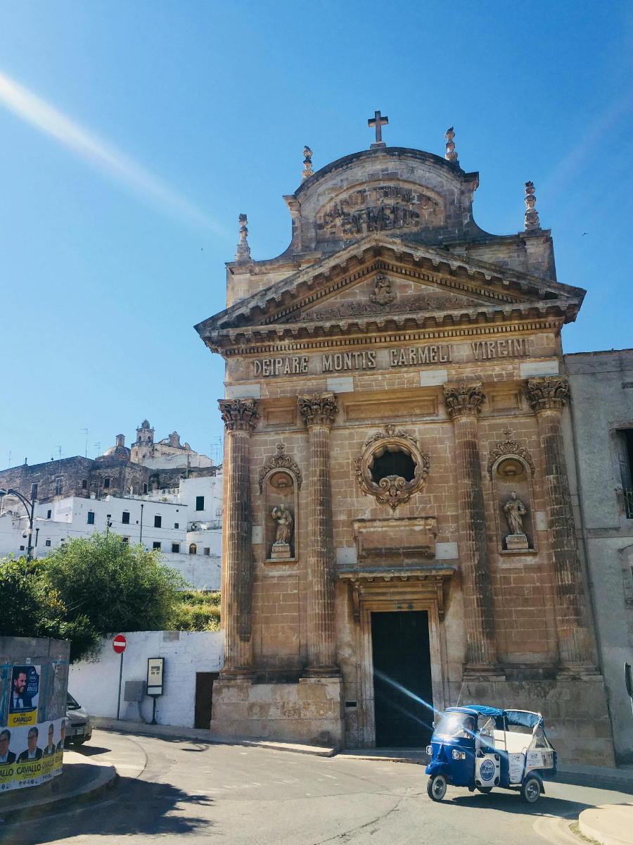 un vell edifici de maó amb un cotxe blau aparcat al davant