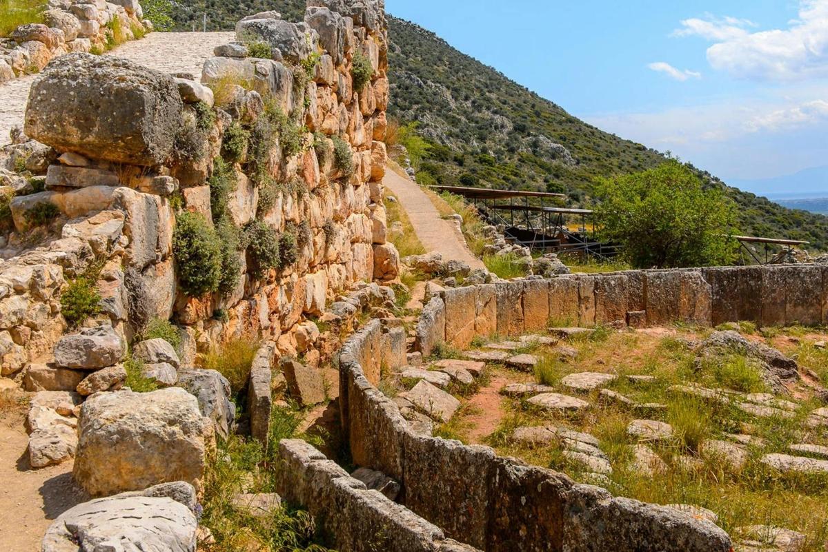 un muro di contenimento in pietra con alberi su una montagna