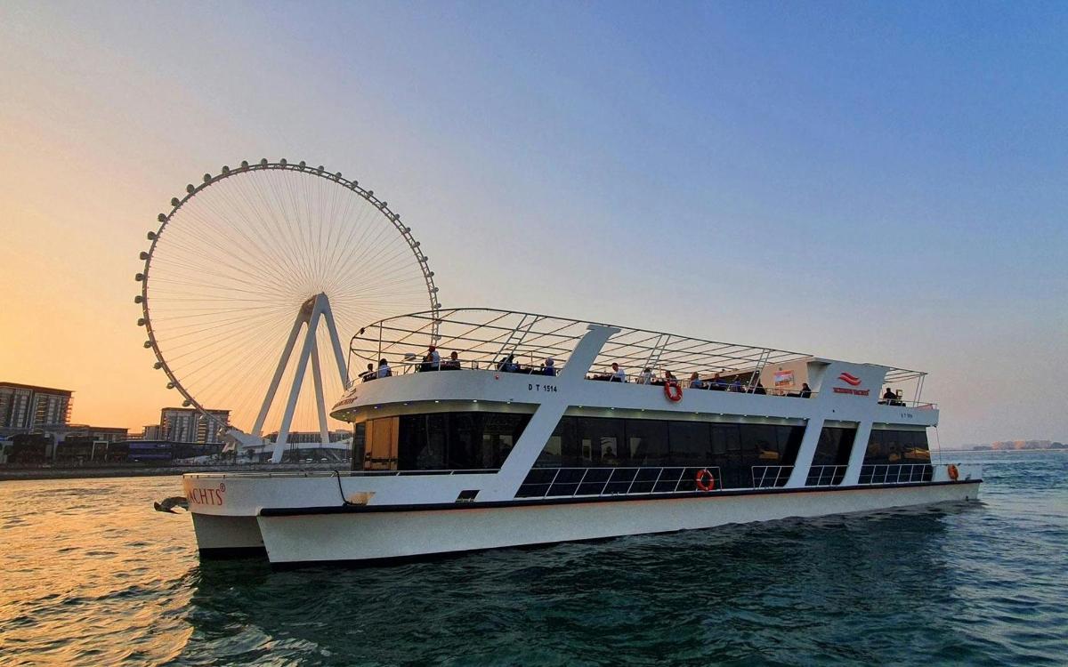 a boat in the water with a ferris wheel in the background
