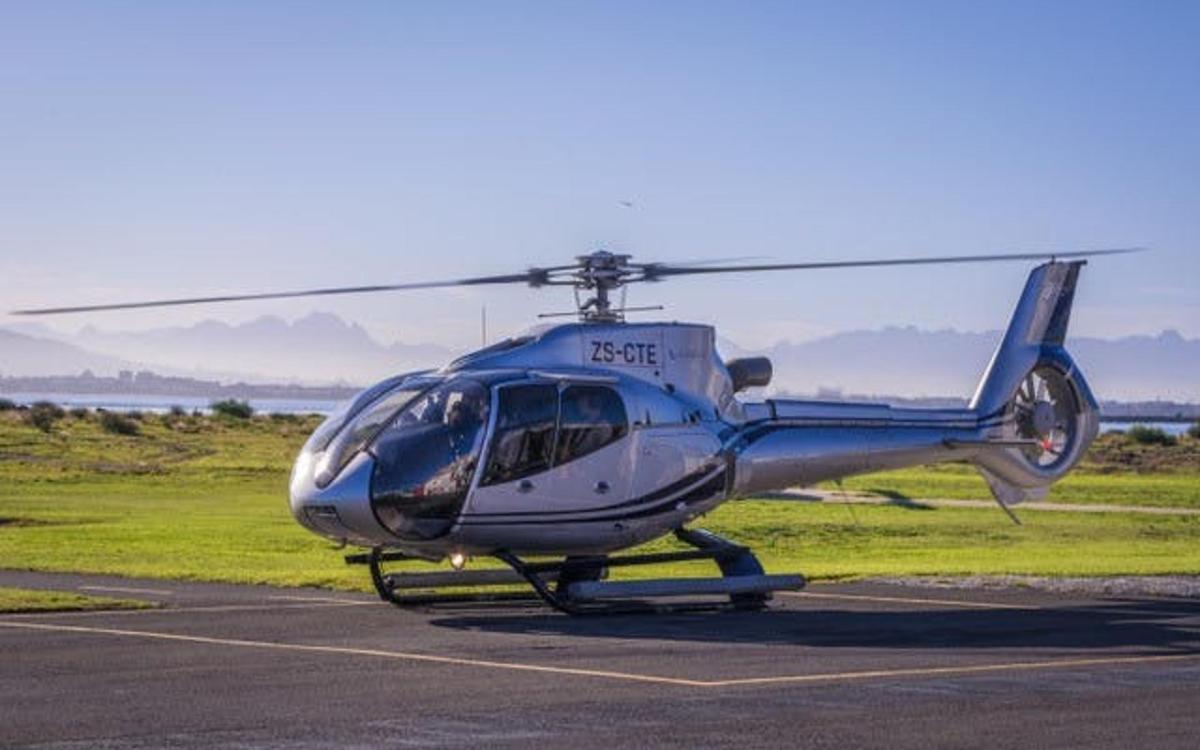 un helicòpter blau i blanc assegut a la pista