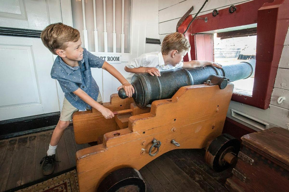 two young boys playing with a wooden toy truck