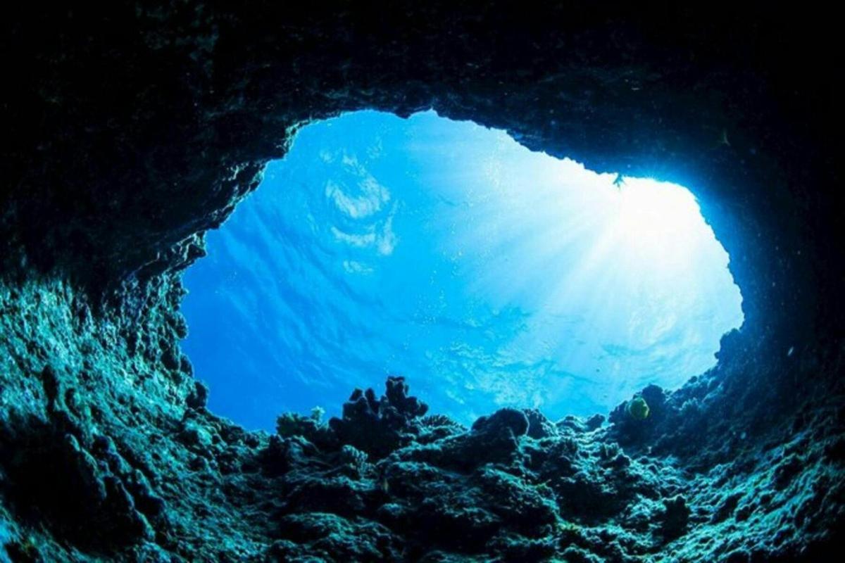 uma caverna azul com o sol brilhando através dela