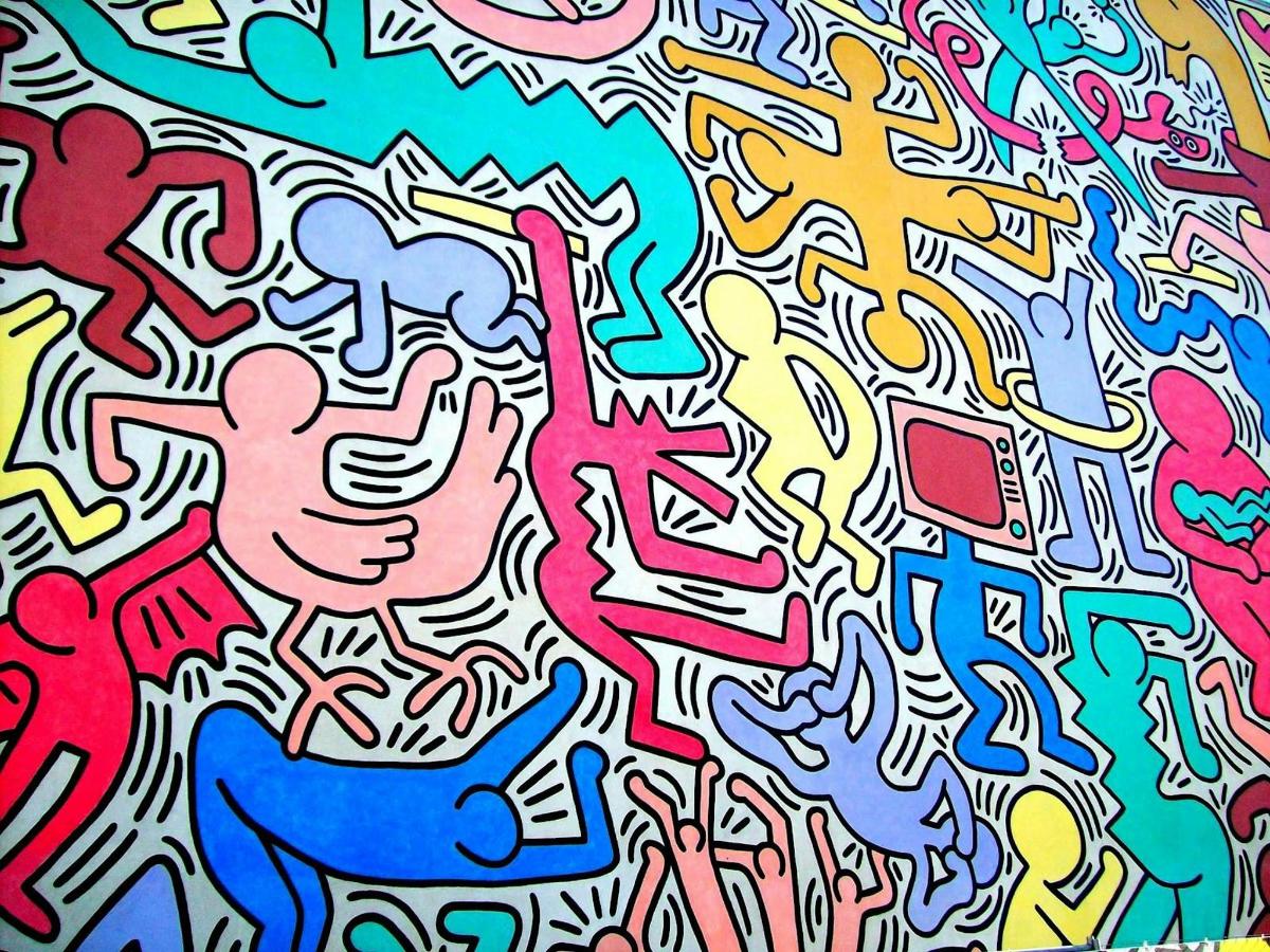 Una pared llena de grafitis de muchos colores diferentes.