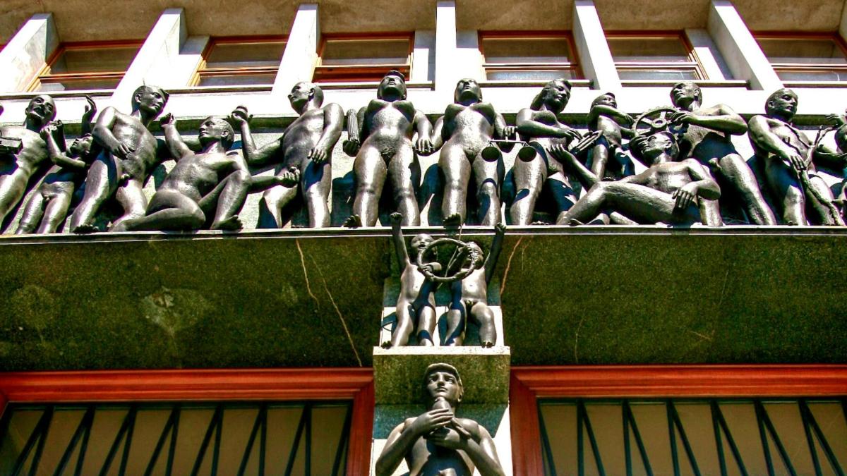 a statue of men on the side of a building