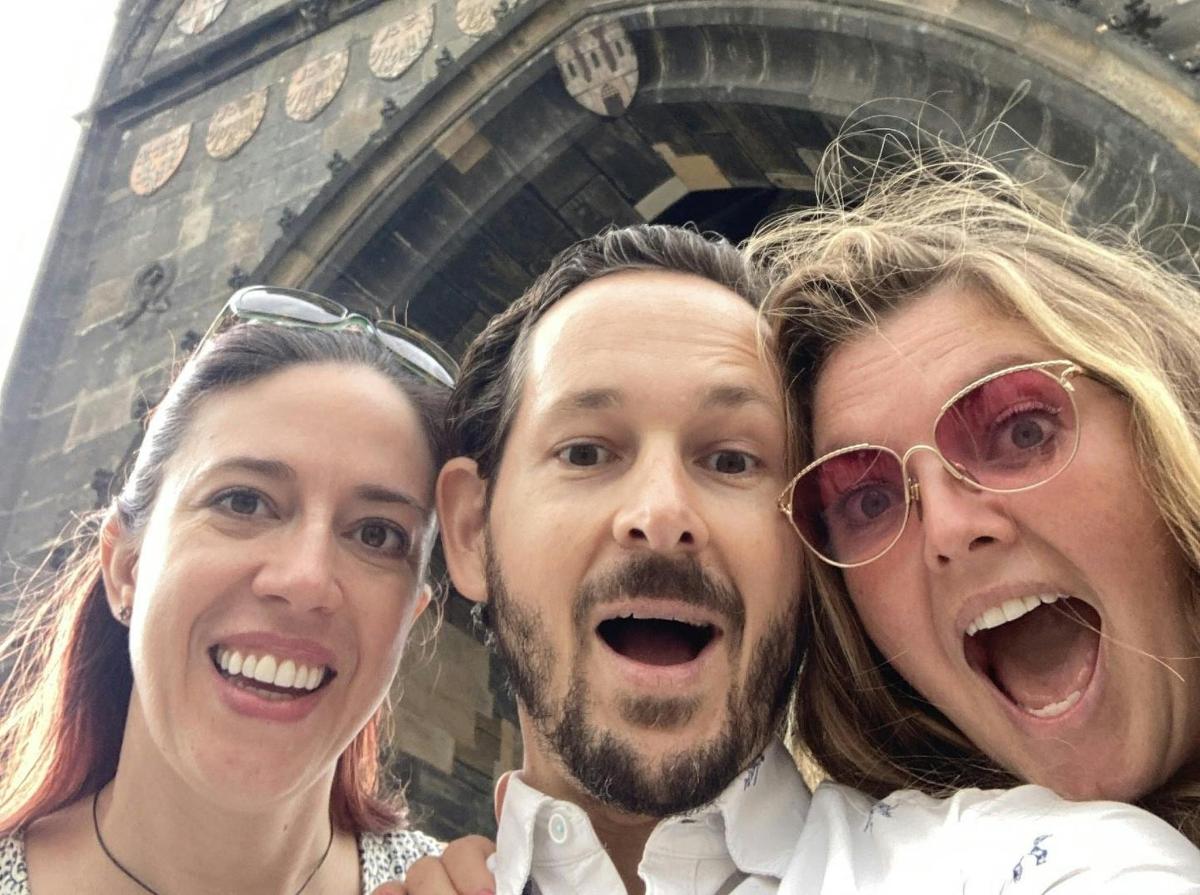 tre persone posano per una foto davanti alla torre Eiffel