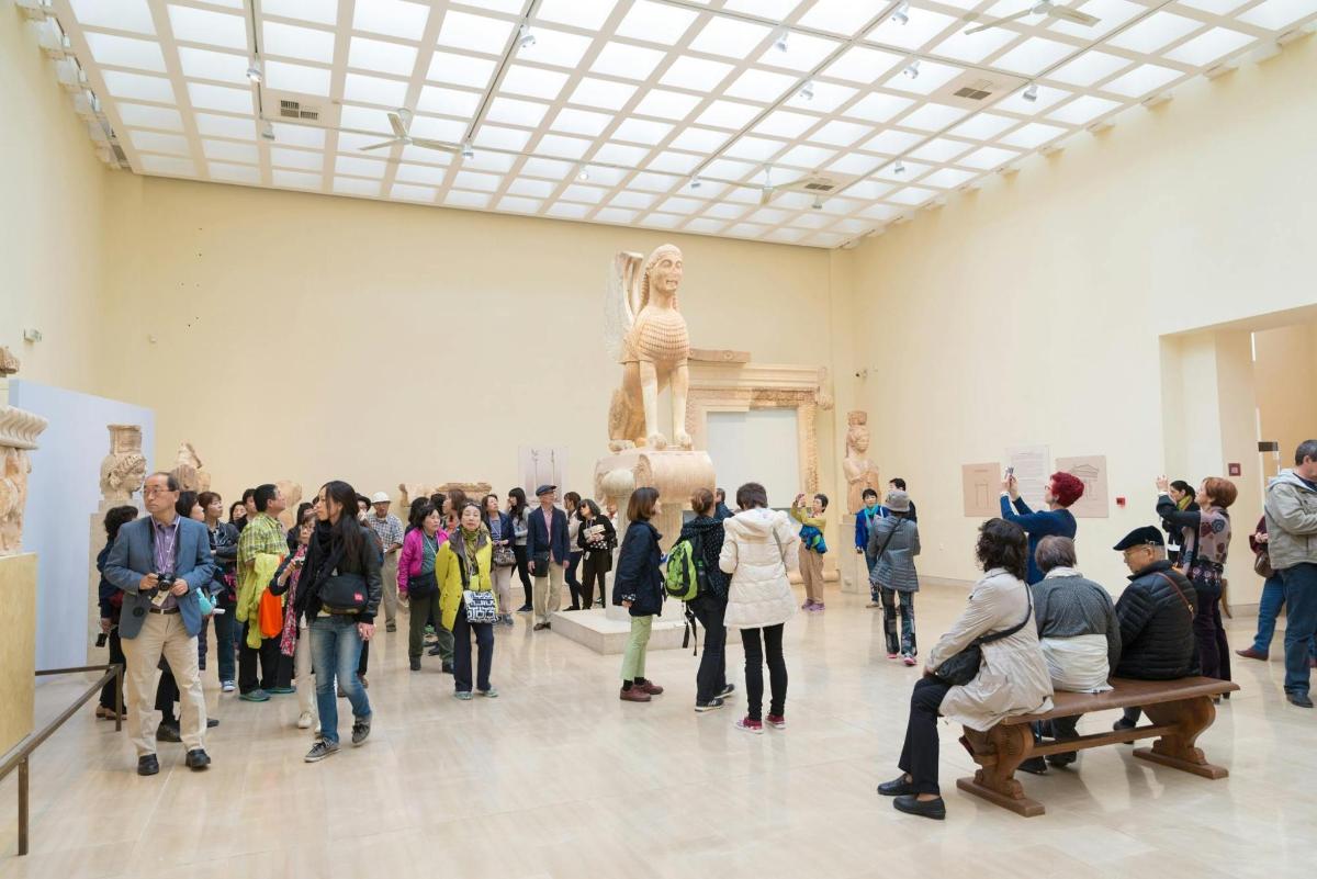 una folla di persone che guarda una scultura in un museo