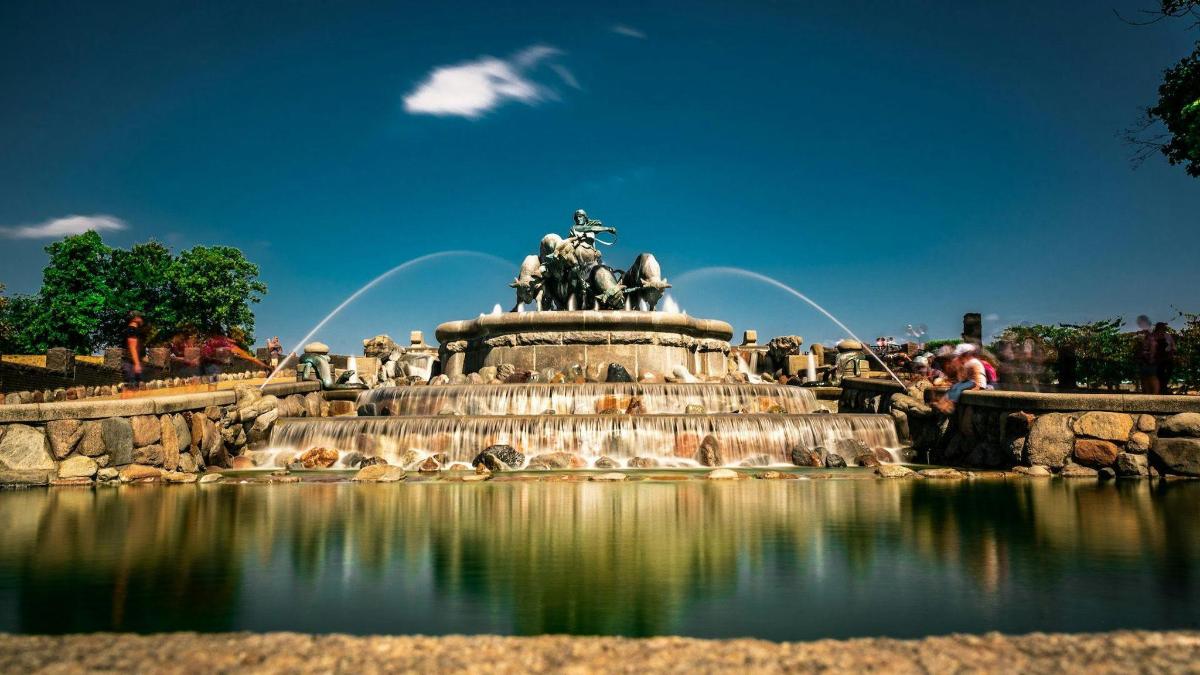 una fontana con una statua al centro di uno stagno