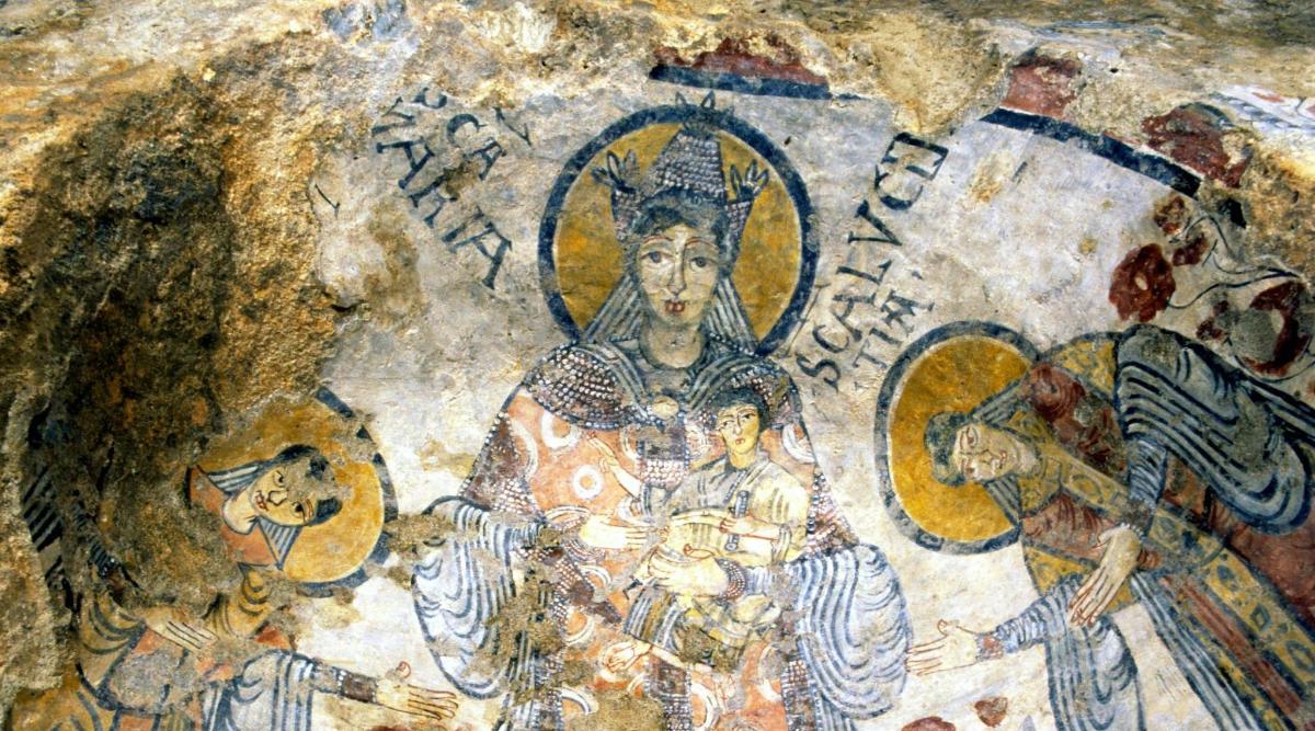 a mural on a cave wall with a statue