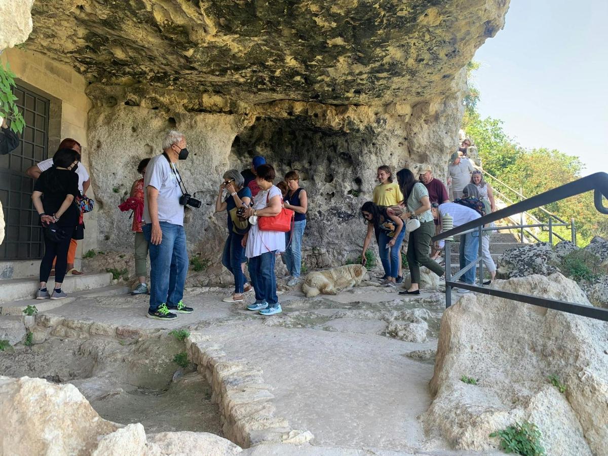 a group of people standing outside of a rock wall
