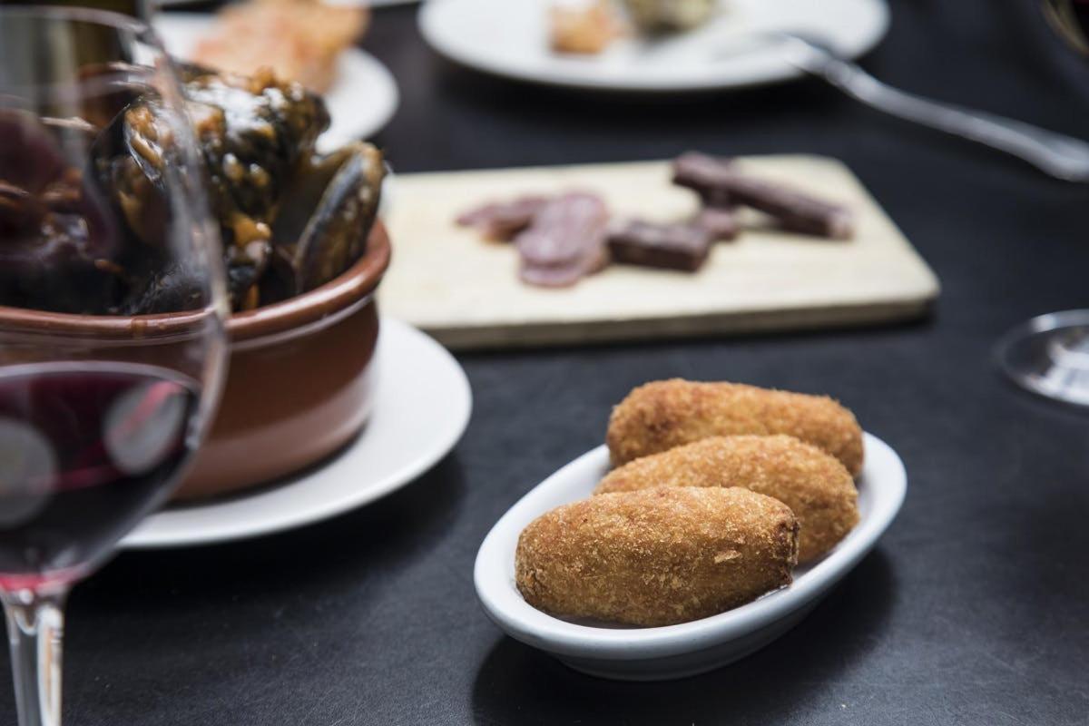 uma mesa com pratos de comida e uma taça de vinho