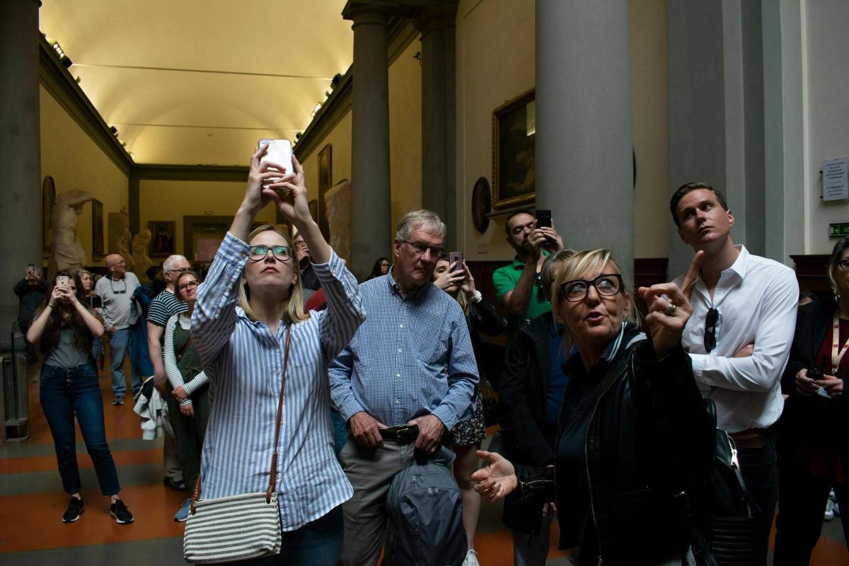 Skupina lidí stojících na chodbě a držících v ruce ovladač Wii