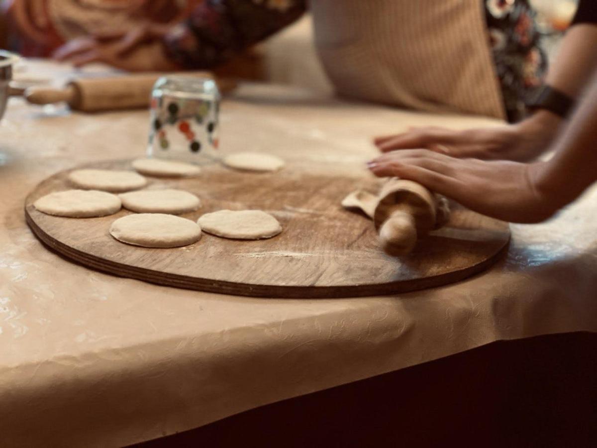uma pessoa fazendo biscoitos em uma tábua de corte sobre uma mesa