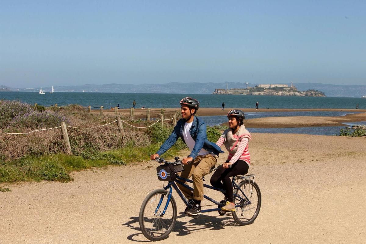 dos personas montando en bicicleta en la playa