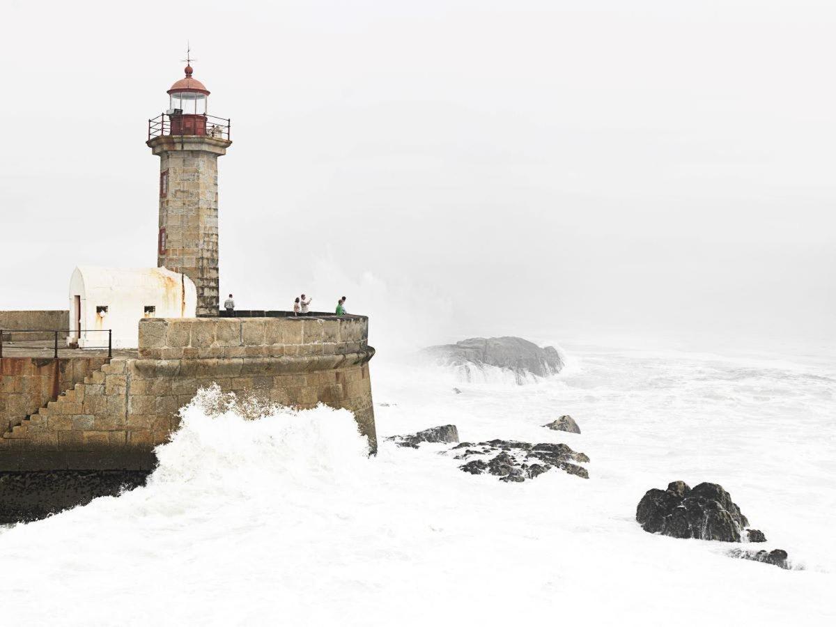 un faro coperto di neve vicino all'oceano