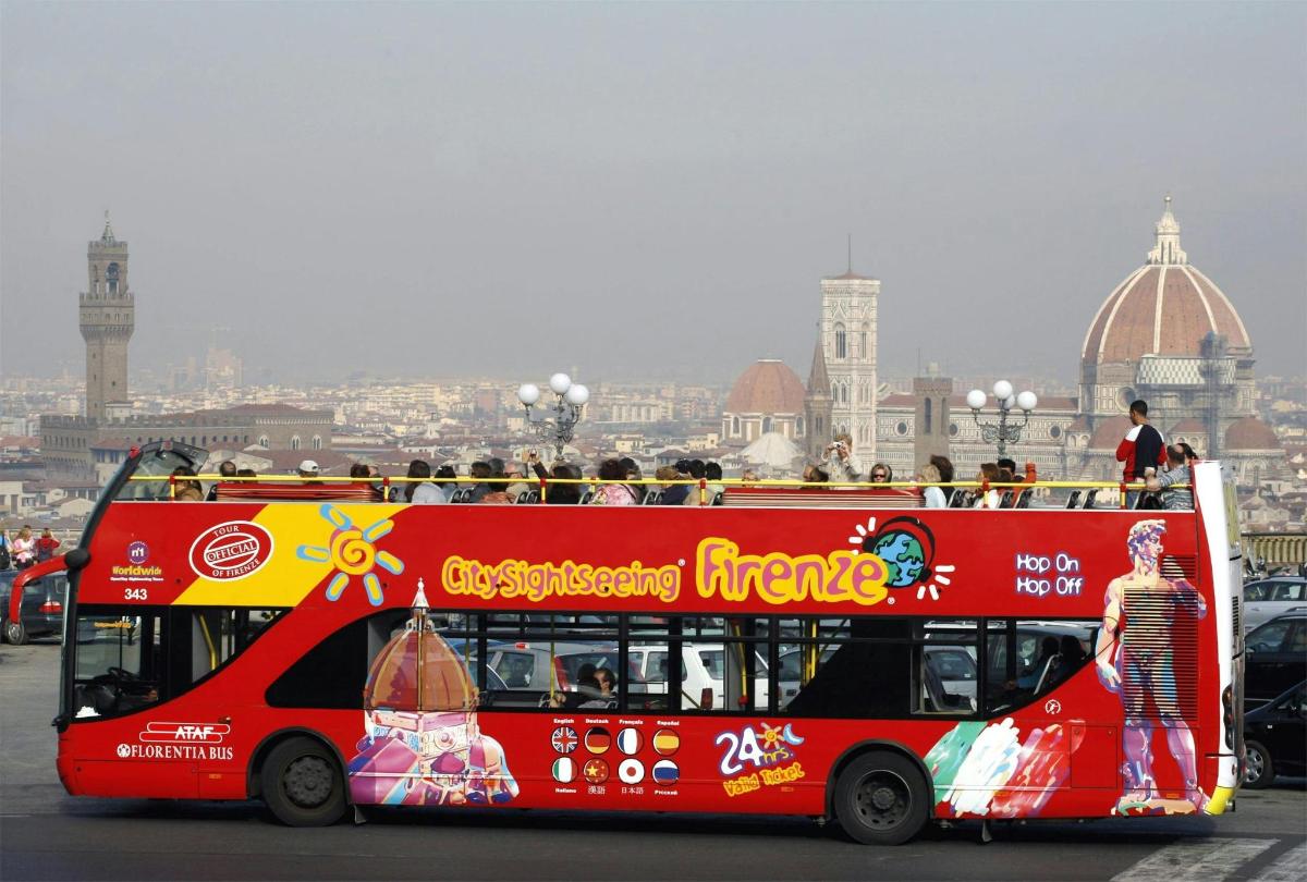 červený dvoupatrový autobus jedoucí po ulici