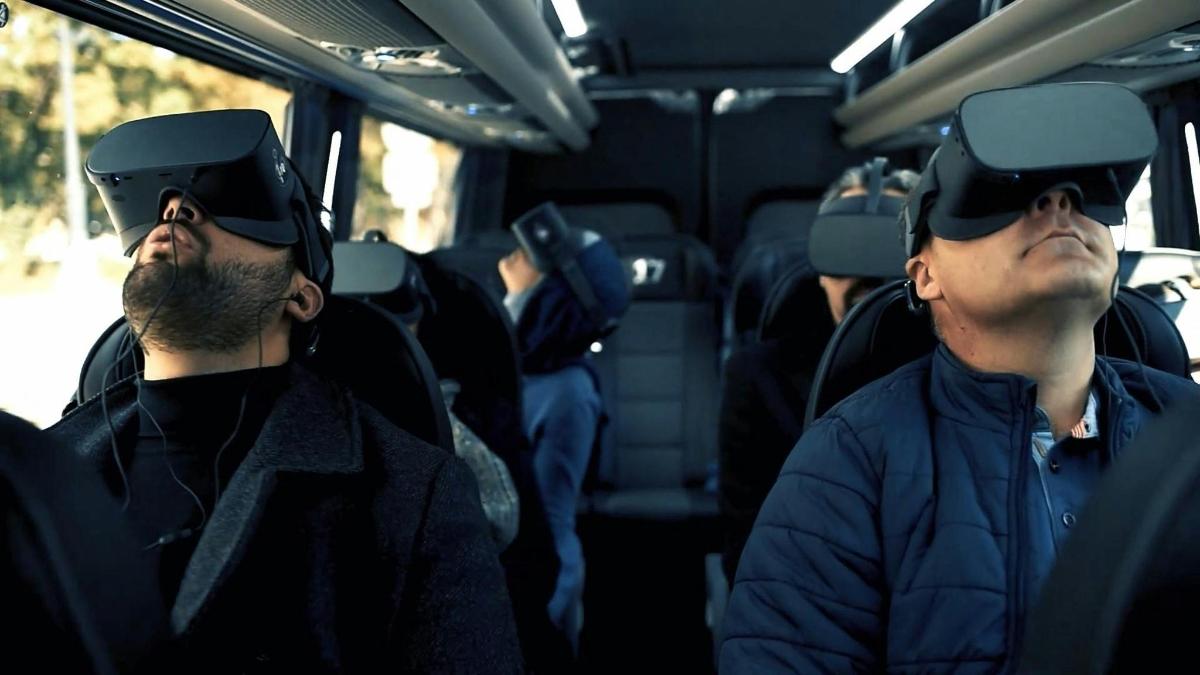 zwei Männer mit Virtual-Reality-Headsets in einem Bus