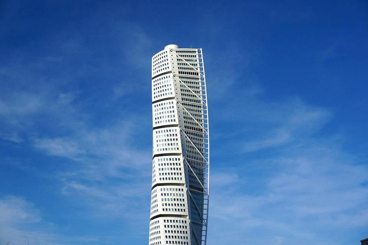Un edificio alto y blanco con un cielo azul al fondo.