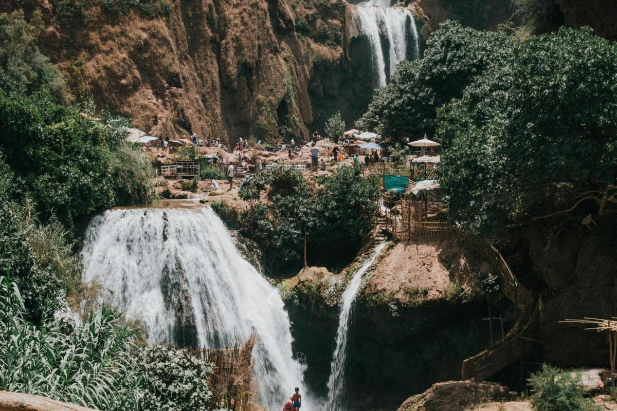 uma cachoeira com pessoas em pé na frente dela