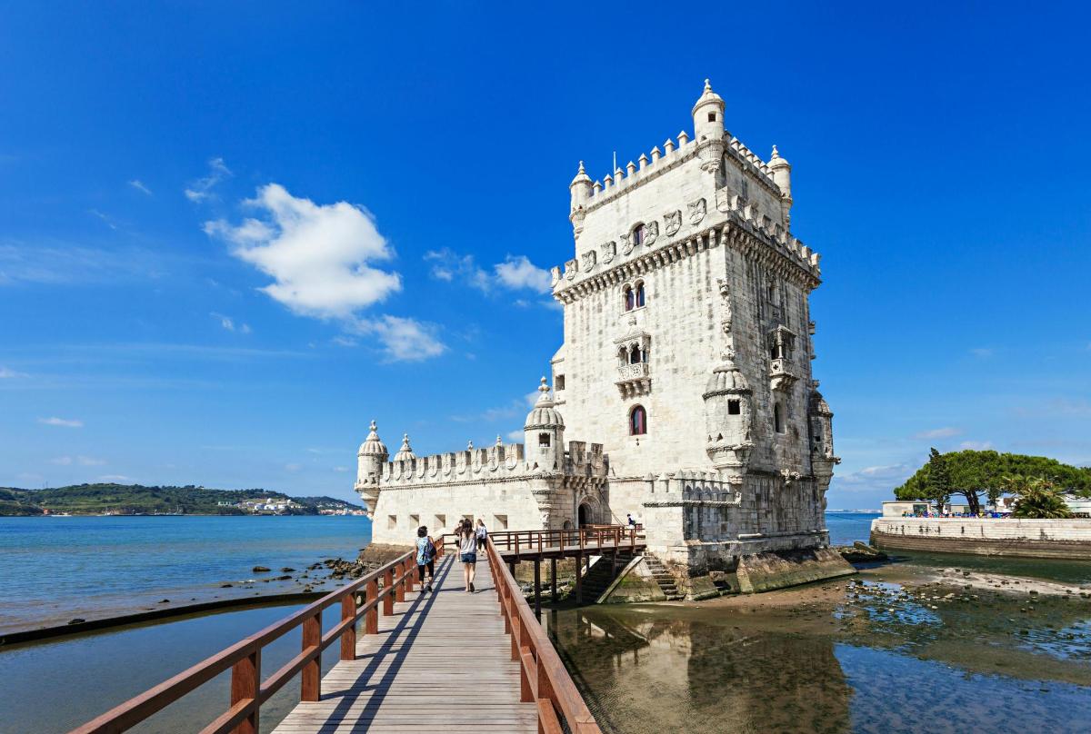 uma torre branca em uma ponte sobre a água