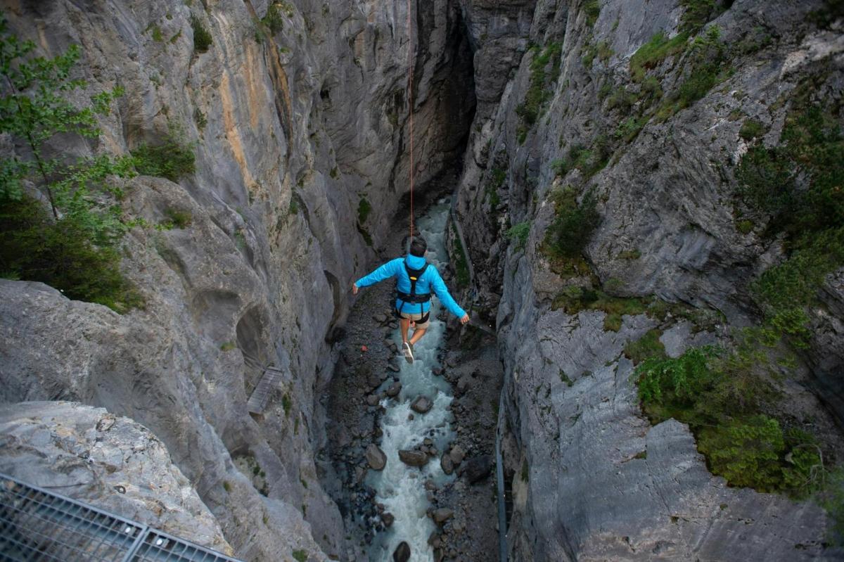 un hombre caminando por un cañón en una montaña