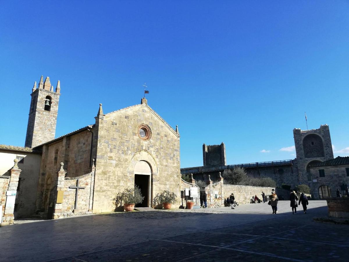 eine alte Steinkirche mit Menschen, die davor spazieren gehen