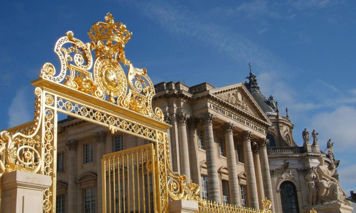 a large gold gate in front of a building