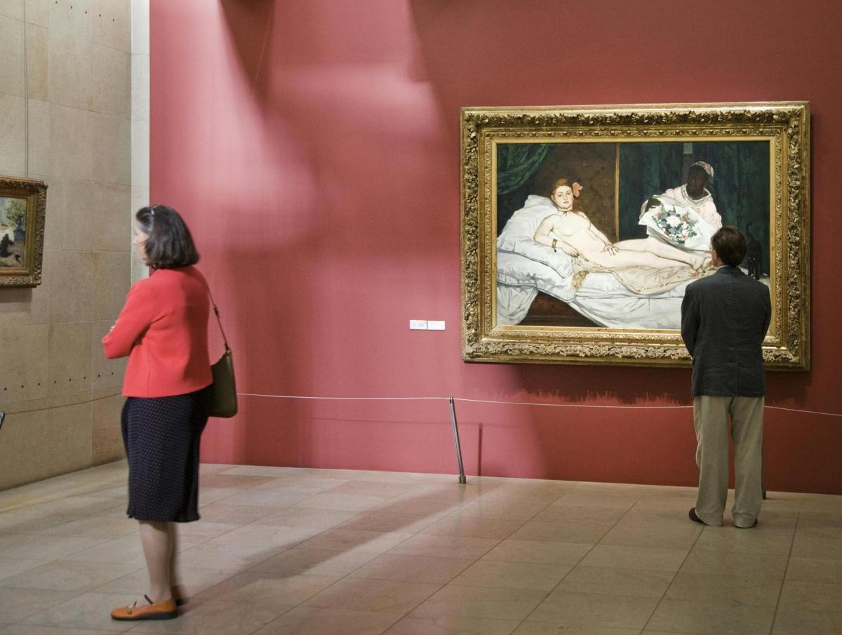 deux personnes regardant un tableau dans un musée