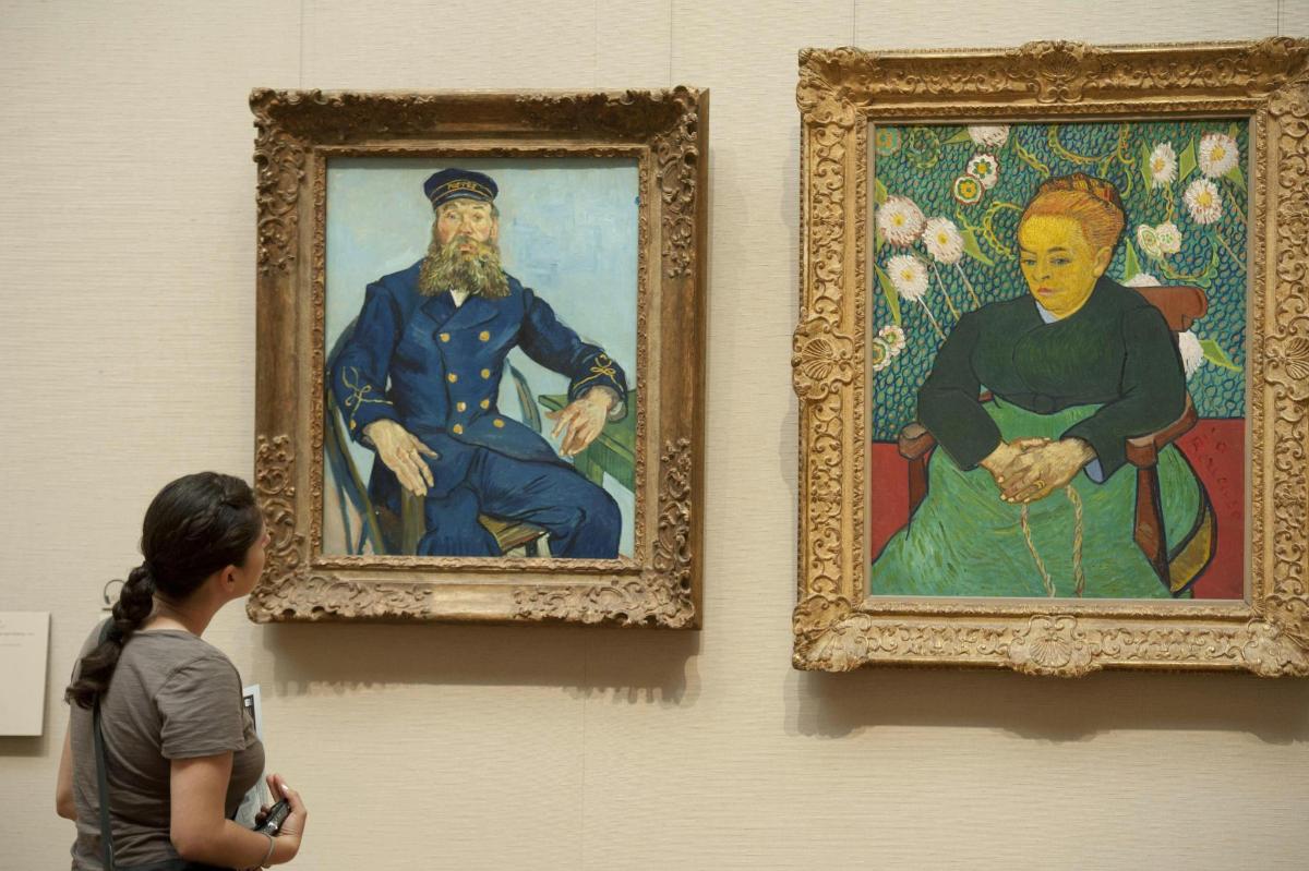 una donna che guarda due dipinti su un muro
