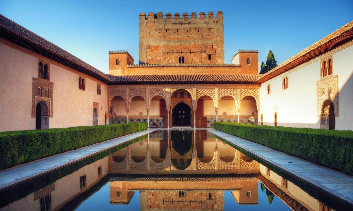 Un patio de un edificio con un castillo al fondo.