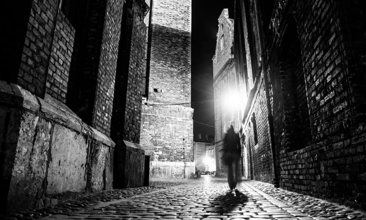 a person walking down an alley at night