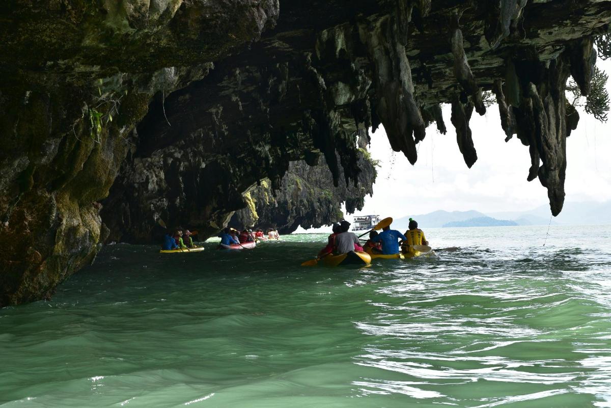 a group of people kayaking in the water in a cave