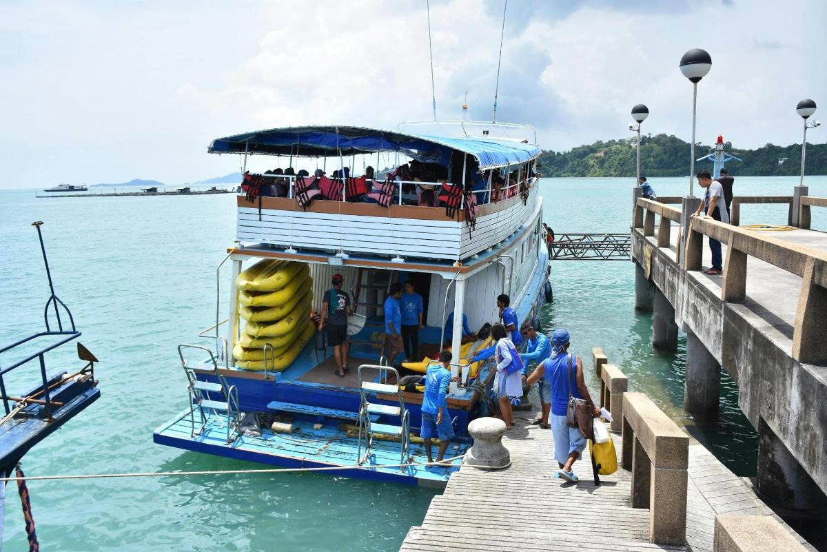 a group of people on a boat at a dock