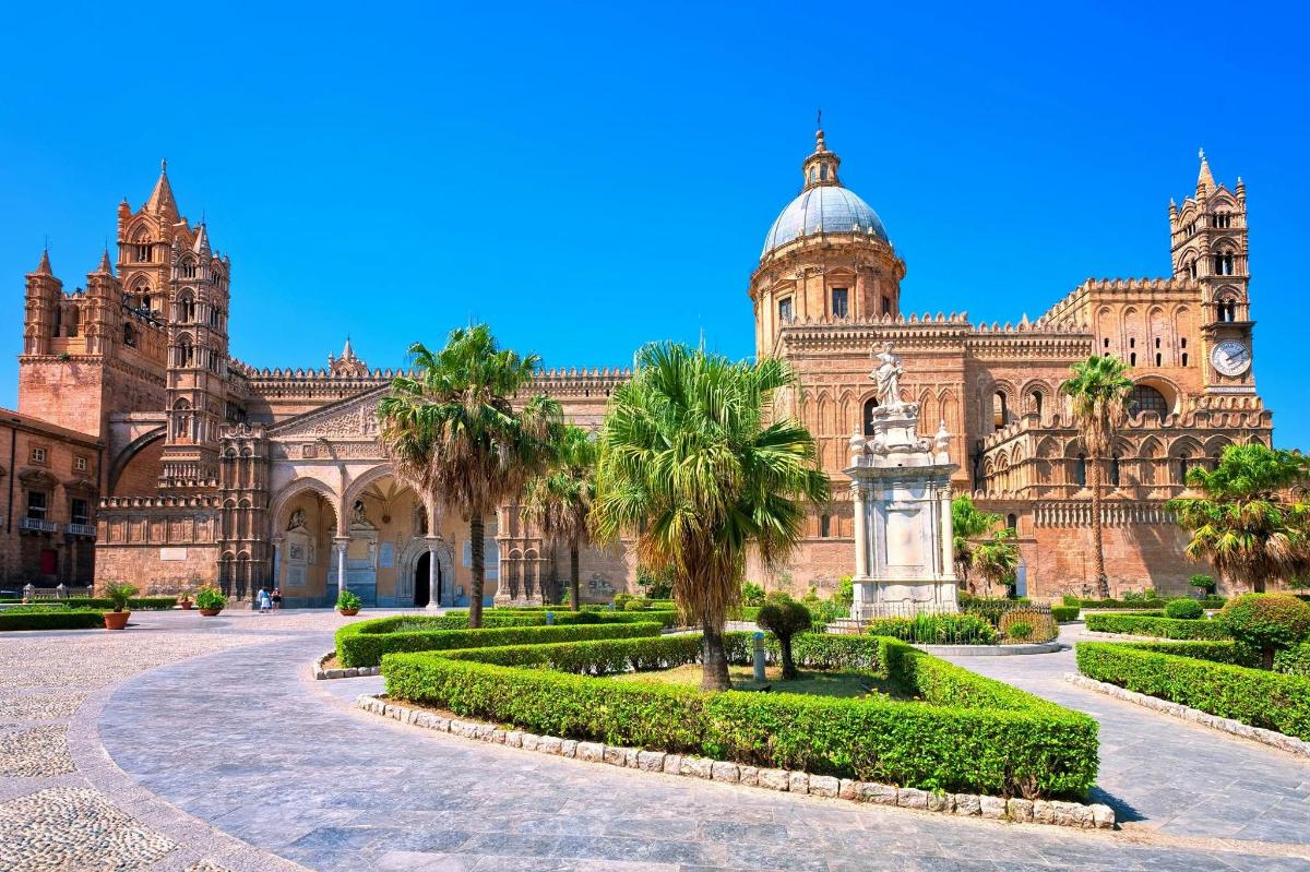 a large building with palm trees and a clock tower
